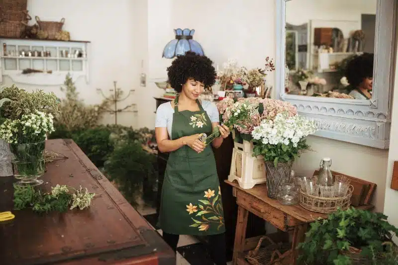 female retail worker in a florist cutting flowers