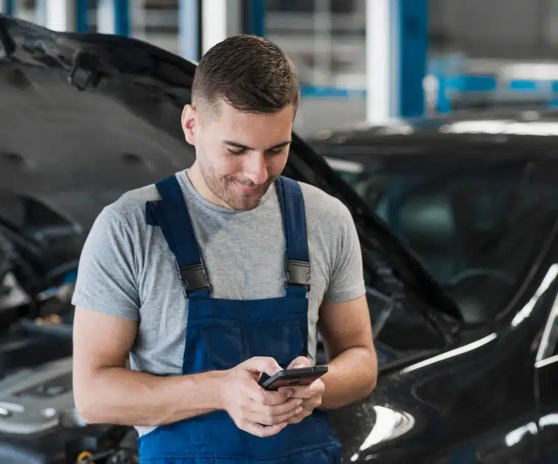 Happy Car Repair Owner checking payments from his card machine