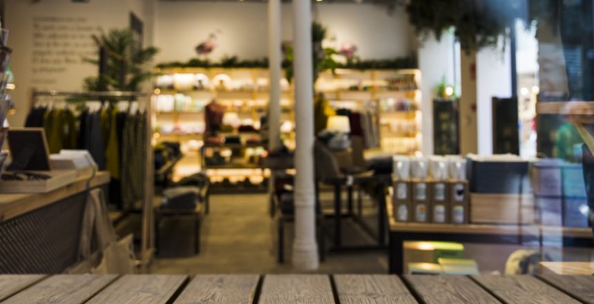 empty modern cafe with wooden features and contrasting white walls with green fooliage.