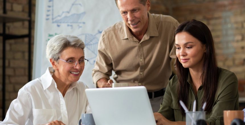 3 different generations sat around a laptop looking at the screen