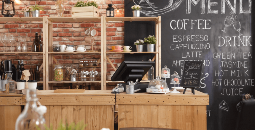 Independent café counter with chalkboard menu showing coffee options including espresso, cappuccino and latte.