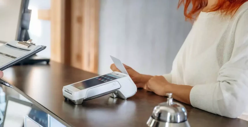 woman making a contactless at a hotel reception desk
